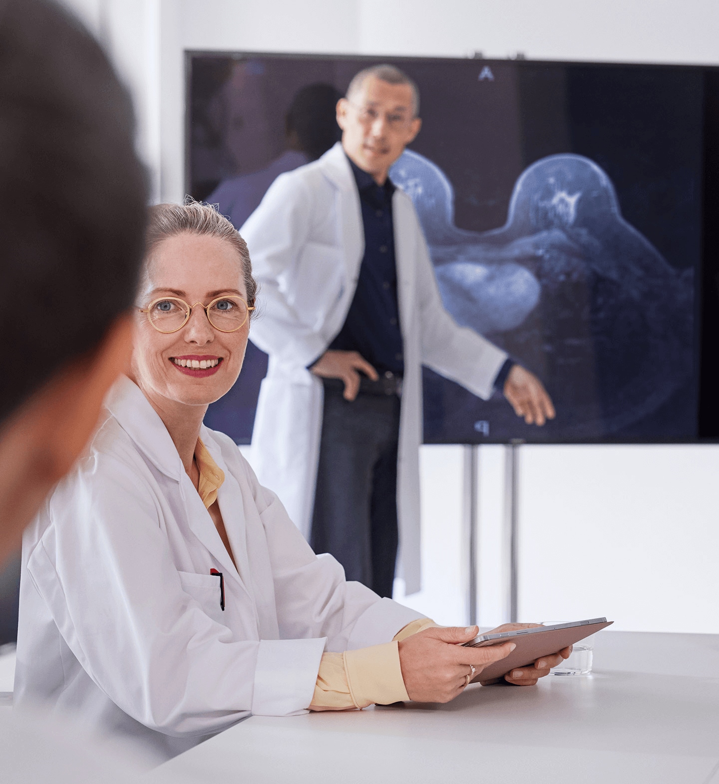 Two radiologists explaining a breast MRI scan to a patient